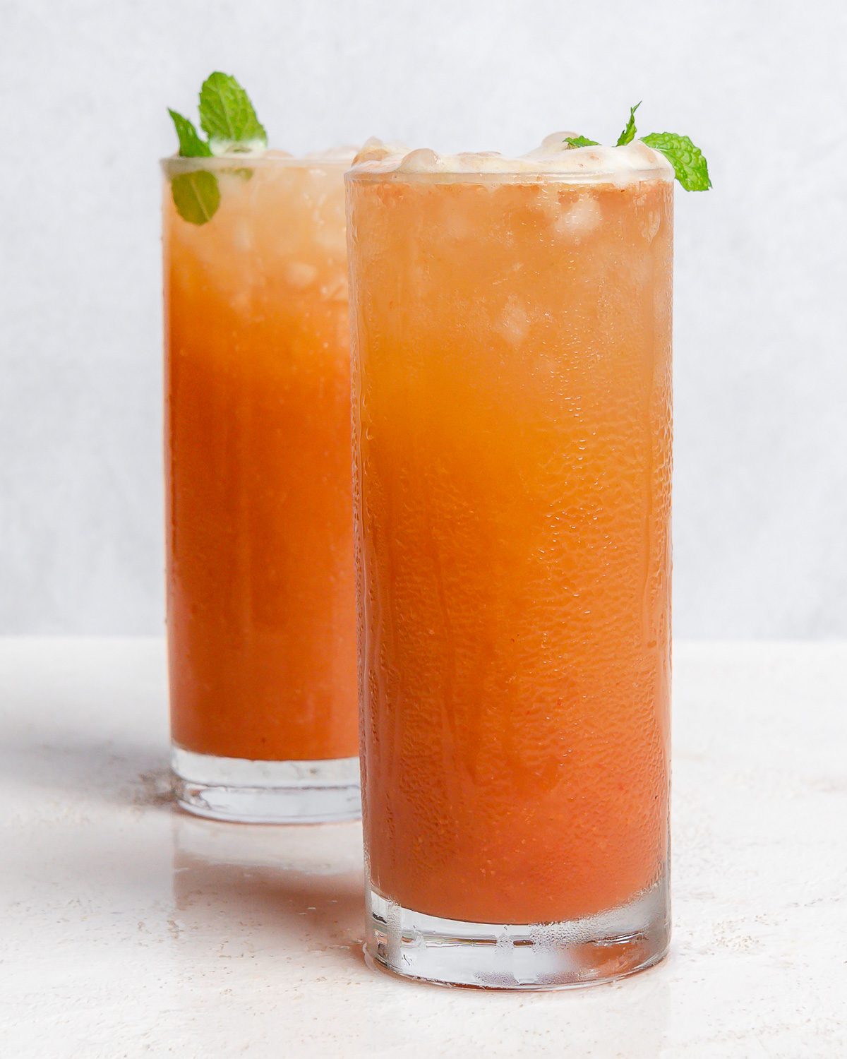 completed Strawberry Pineapple Mocktail in two glasses against a white surface