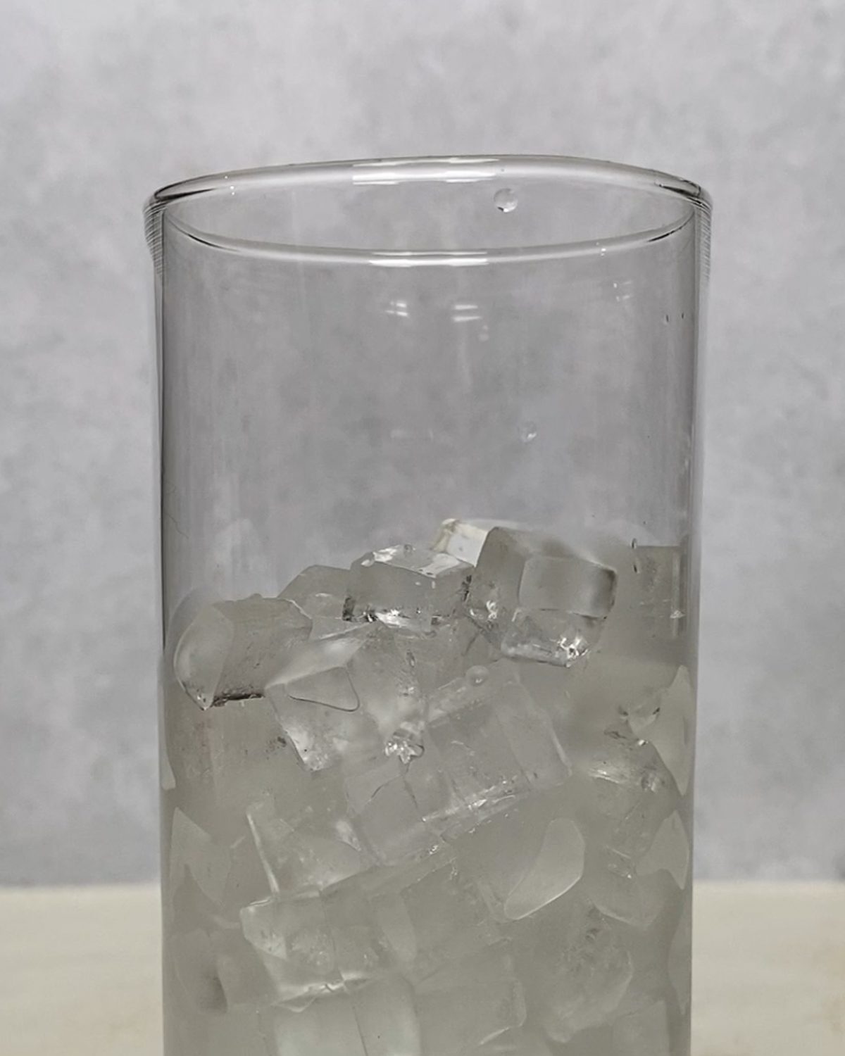 glass of ice for Strawberry Pineapple Mocktail against a light surface