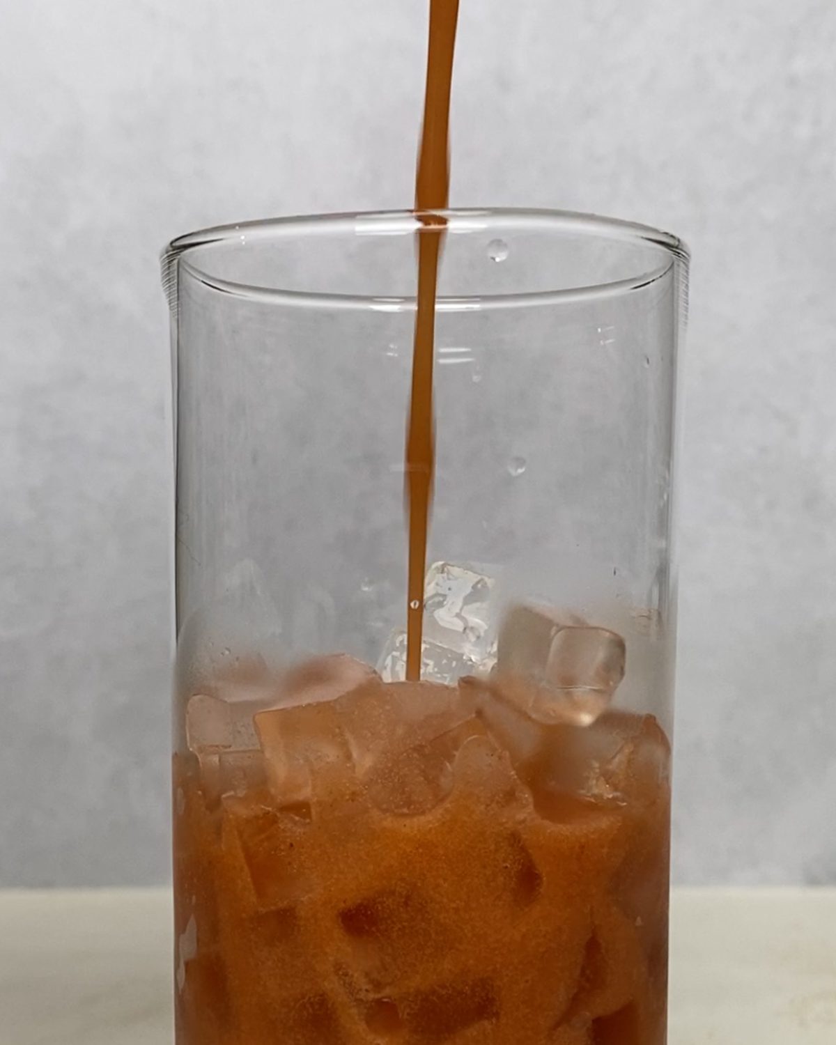 process of pouring Strawberry Pineapple Mocktail into glass