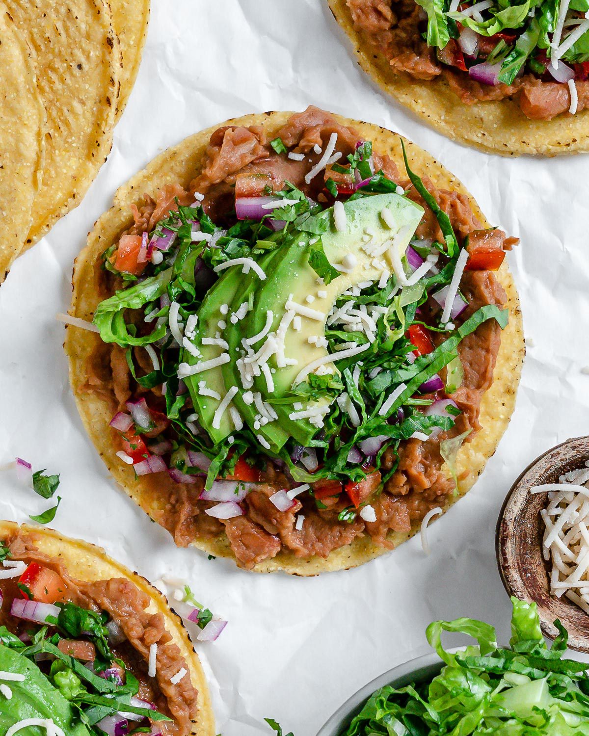 completed Vegan Bean Tostadas with tostadas in the background against a light surface