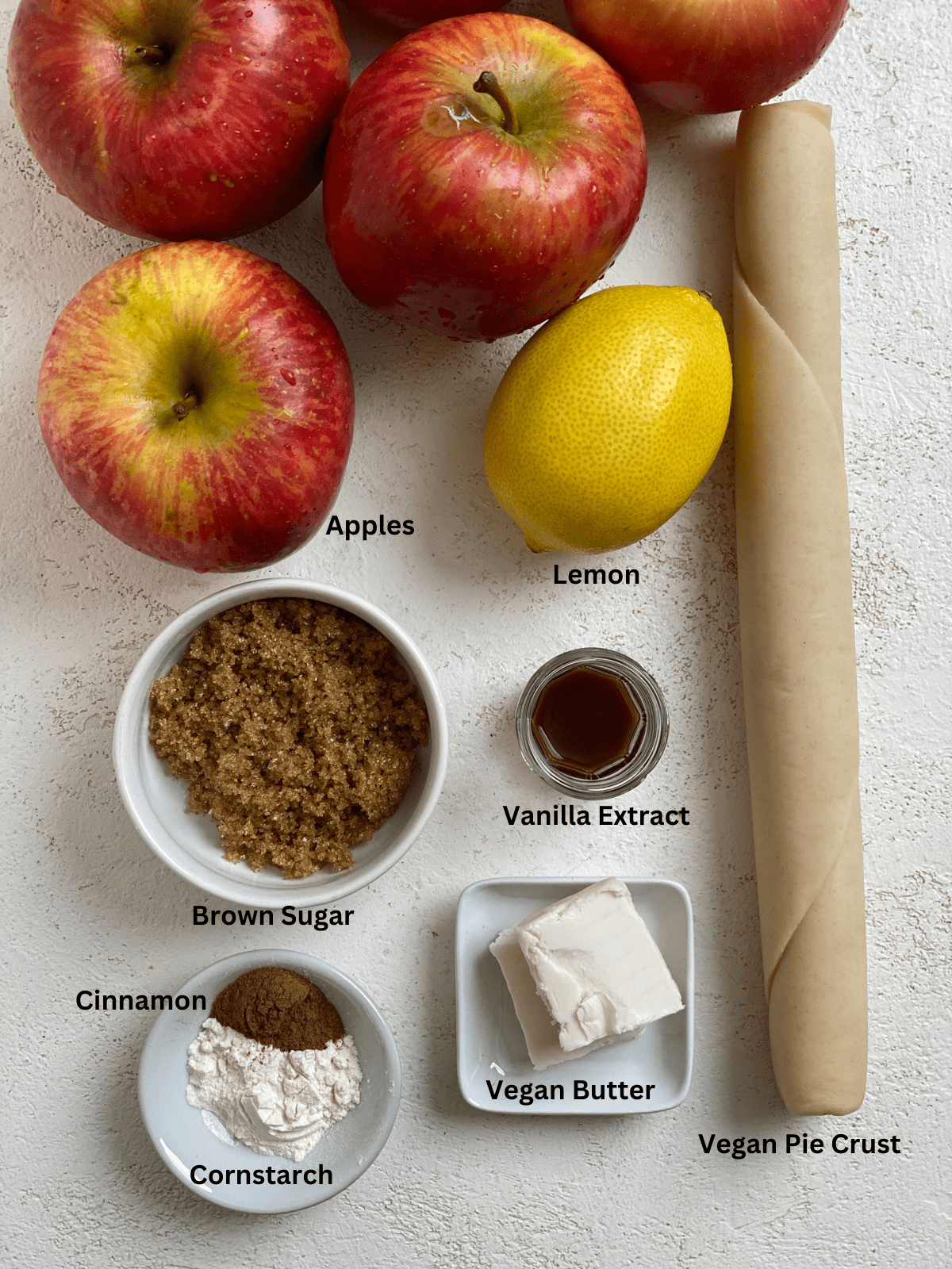Ingredients for Vegan Apple Pie Baked Apples measured out on a white surface.