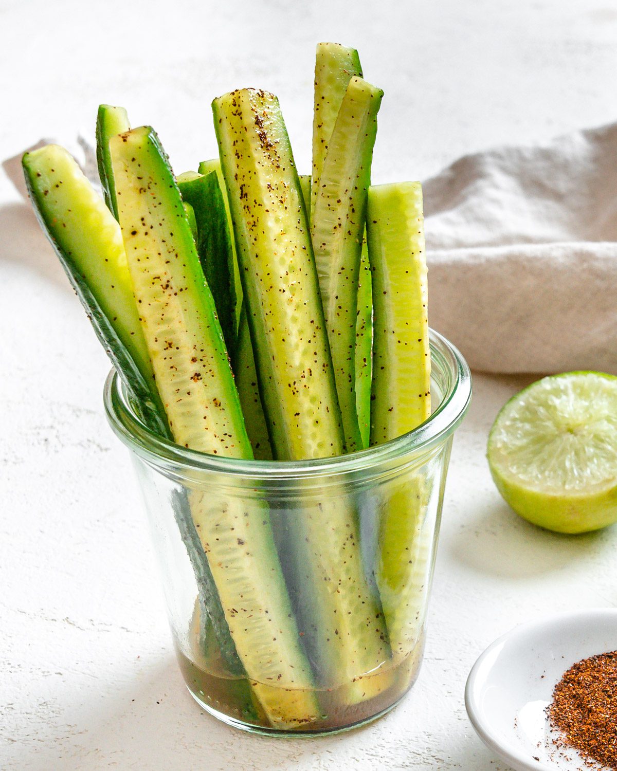 completed Cucumbers with Tajin in a clear glass against a light background