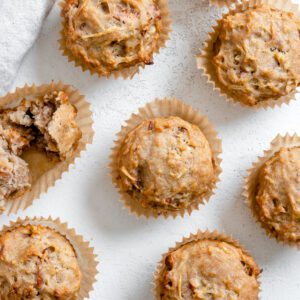 several completed Vegan Apple Muffins spread out on a white surface
