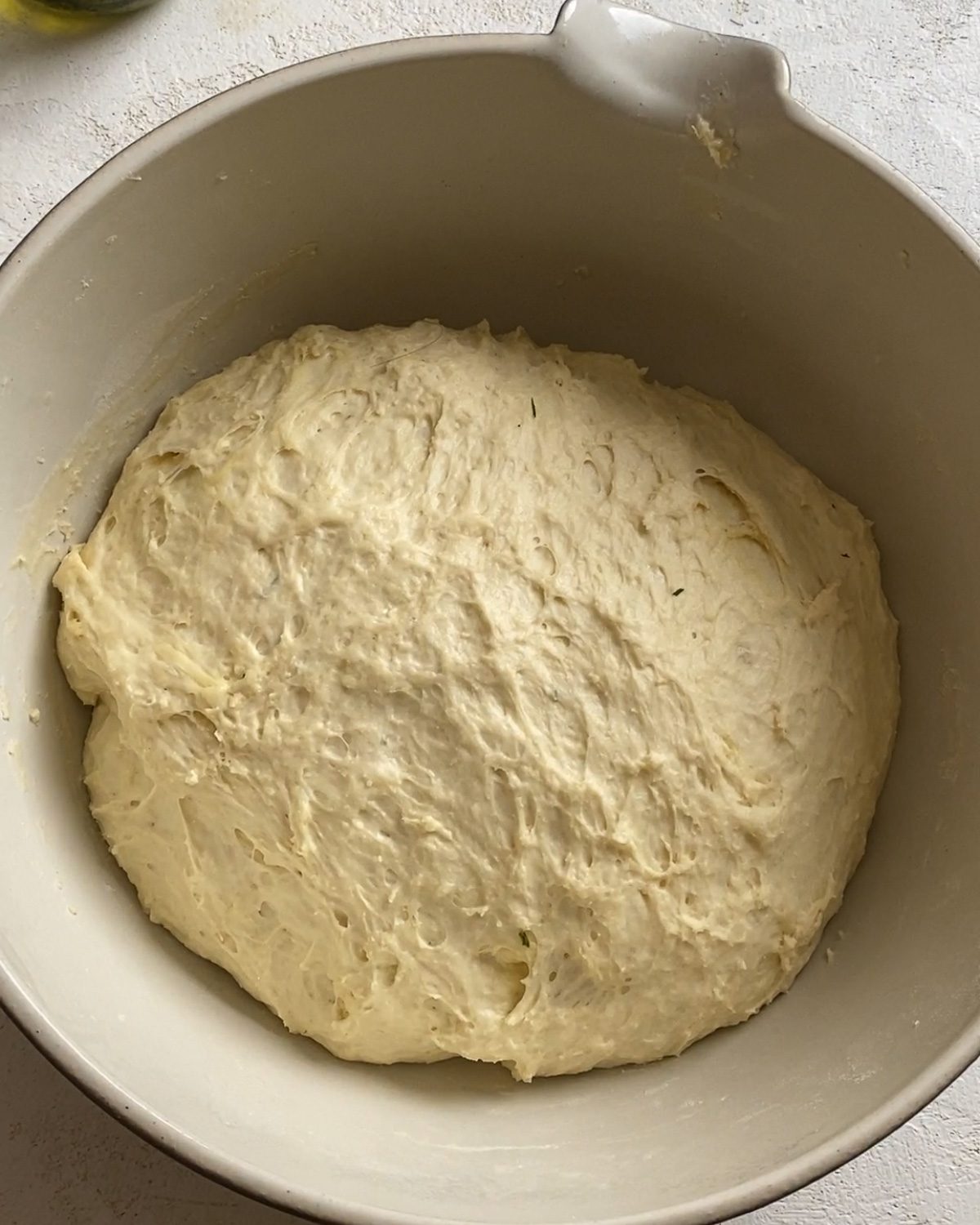 post rising of dough in white bowl