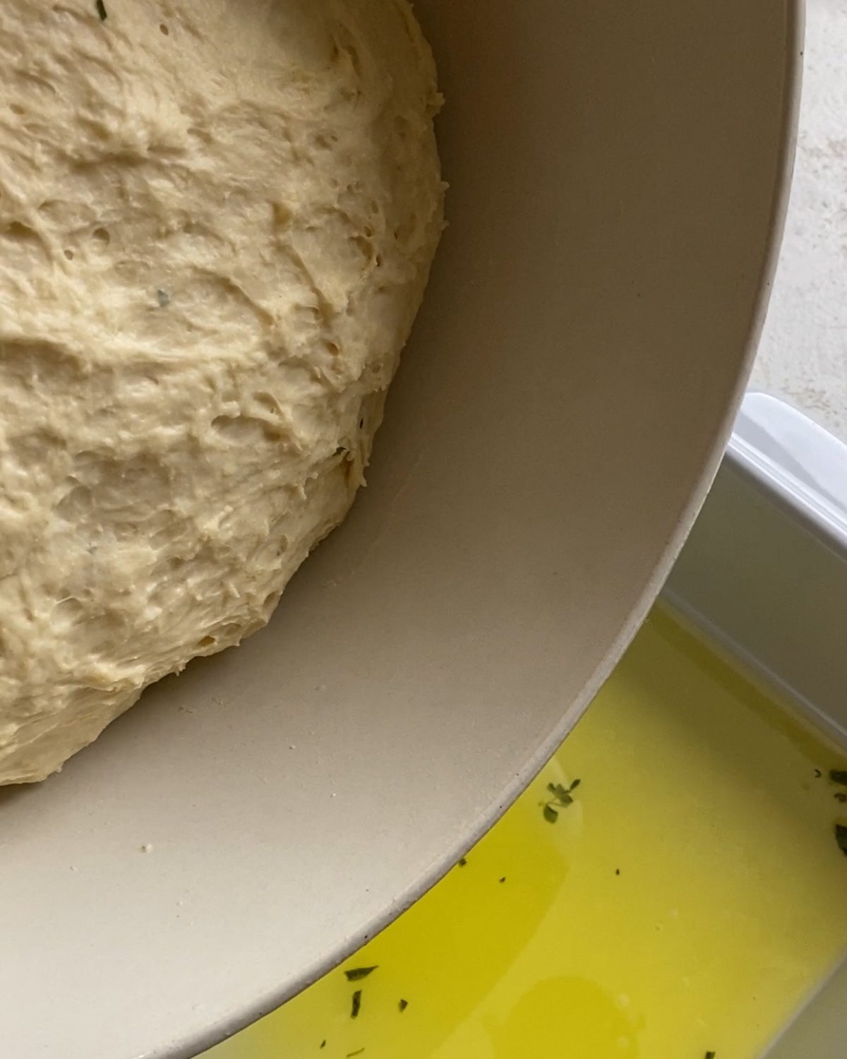 process of adding dough to pan of oil and herb mixture