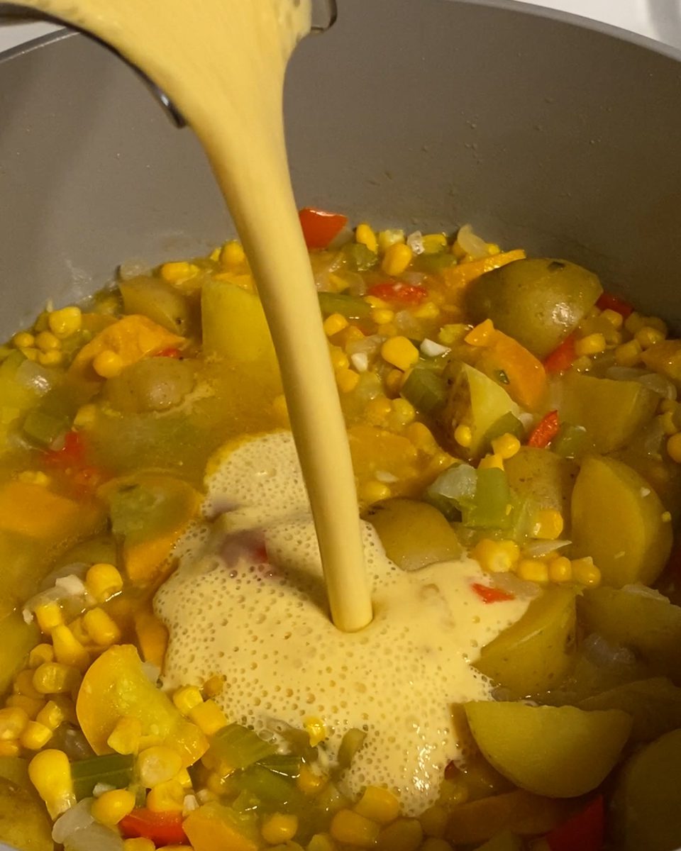 process of adding blended corn mixture to pan of veggies