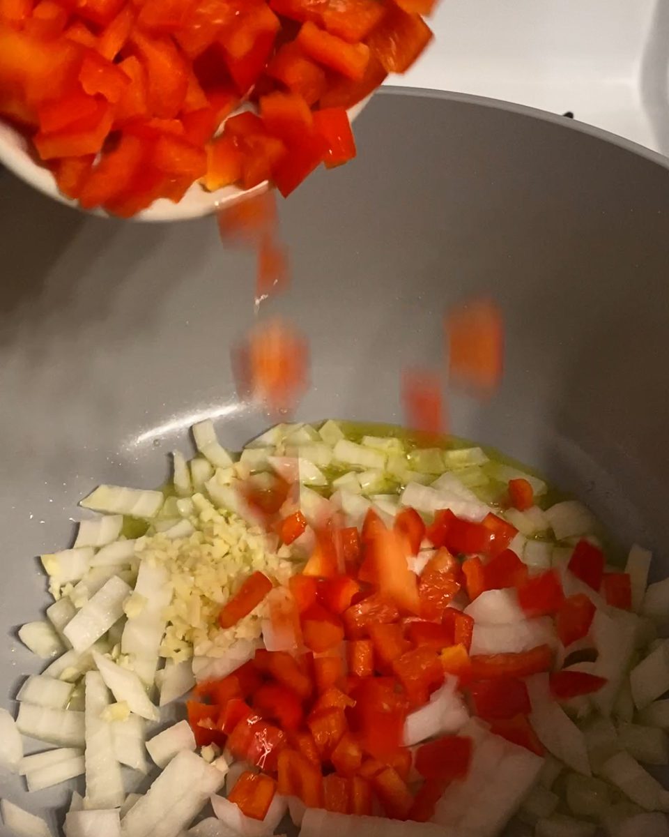 process of adding bell pepper to pan