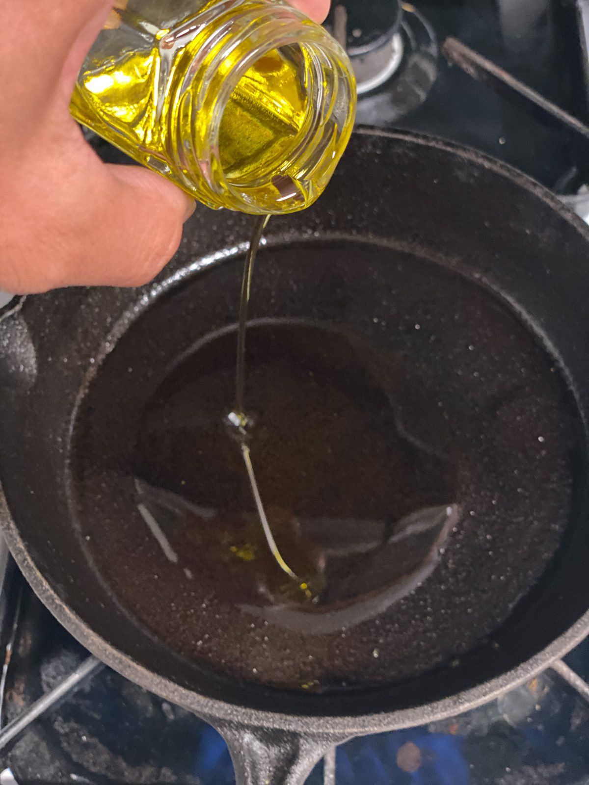 process shot of oil being poured into pan