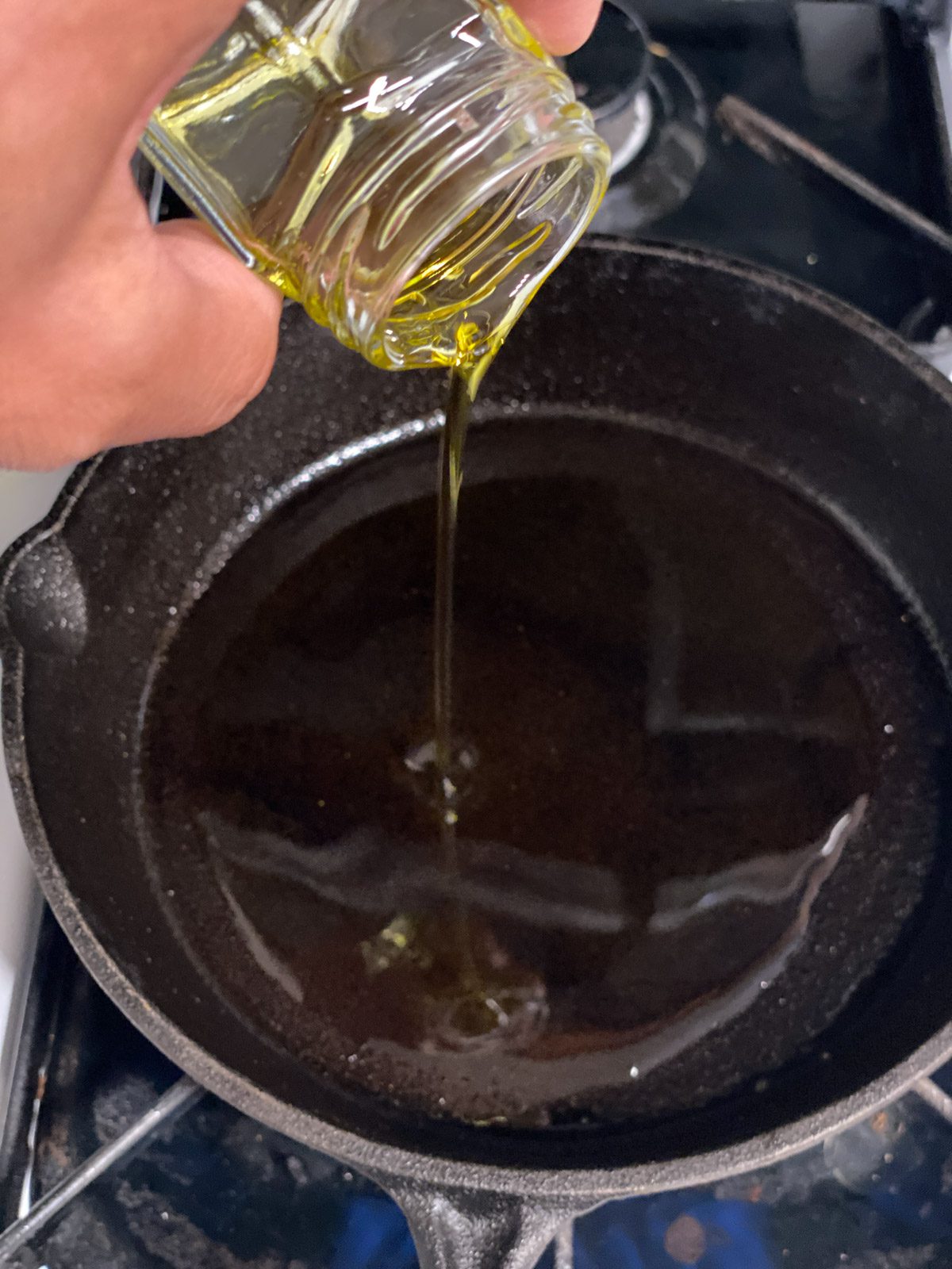 process shot of oil being poured into pan