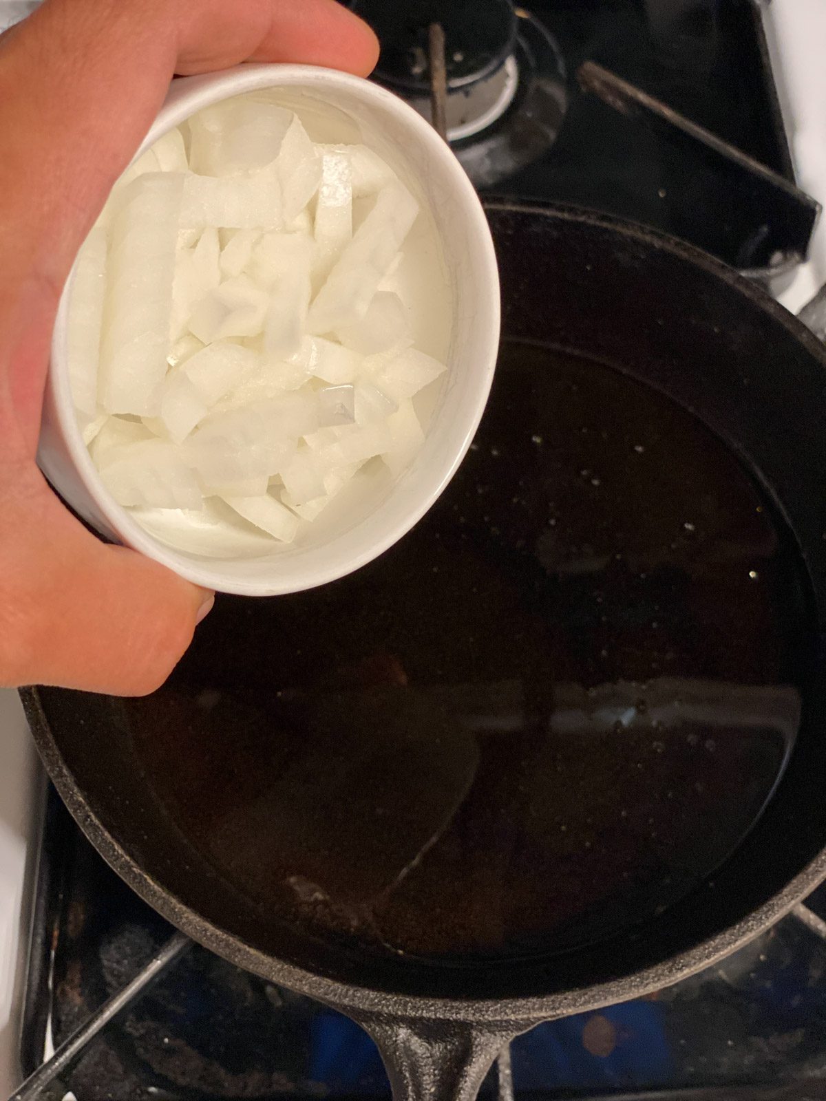 process shot of diced onion being poured into pan