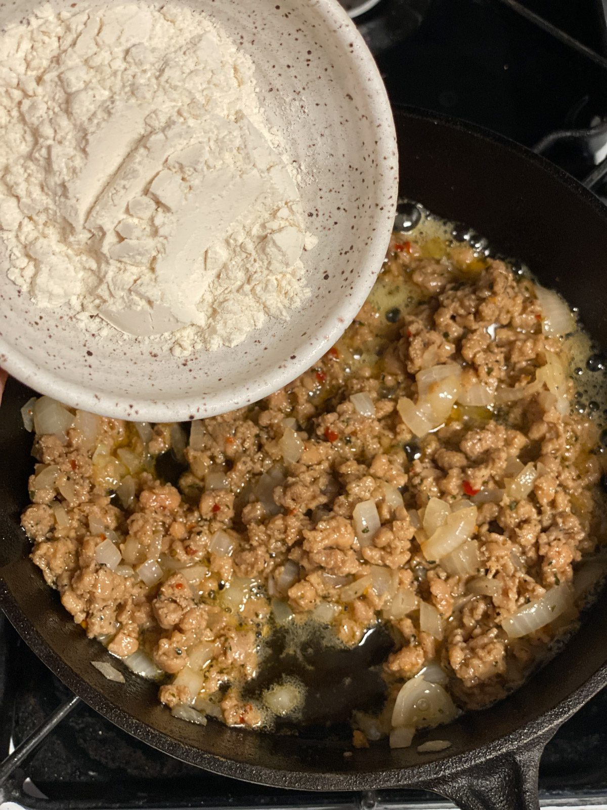 process shot of flour being added to pan