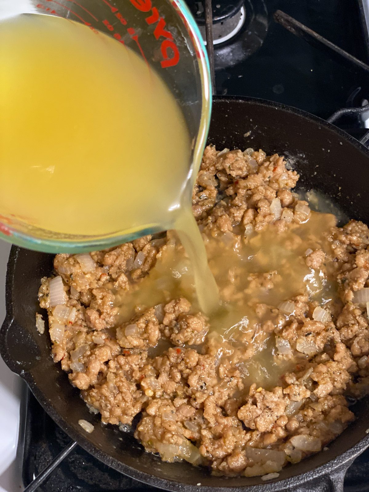 process shot of broth being added to pan