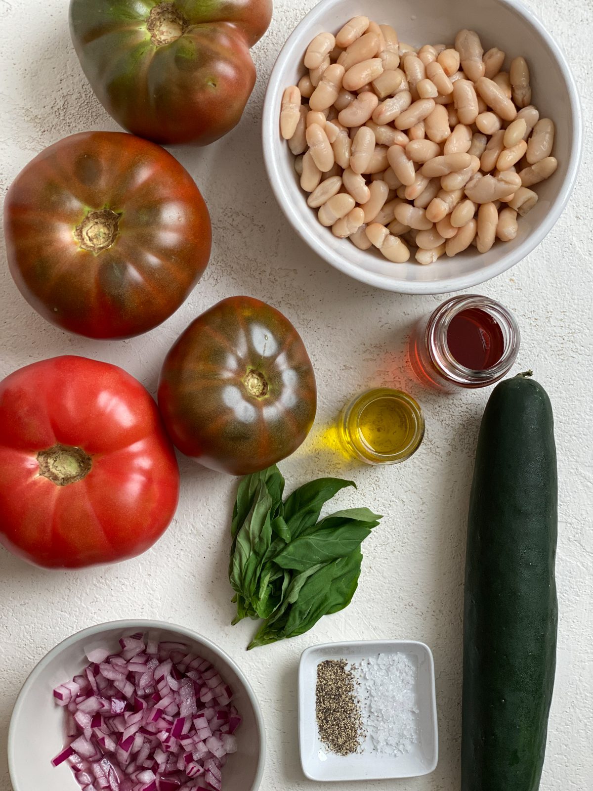 ingredients for Easy Mediterranean White Bean Salad against a white surface