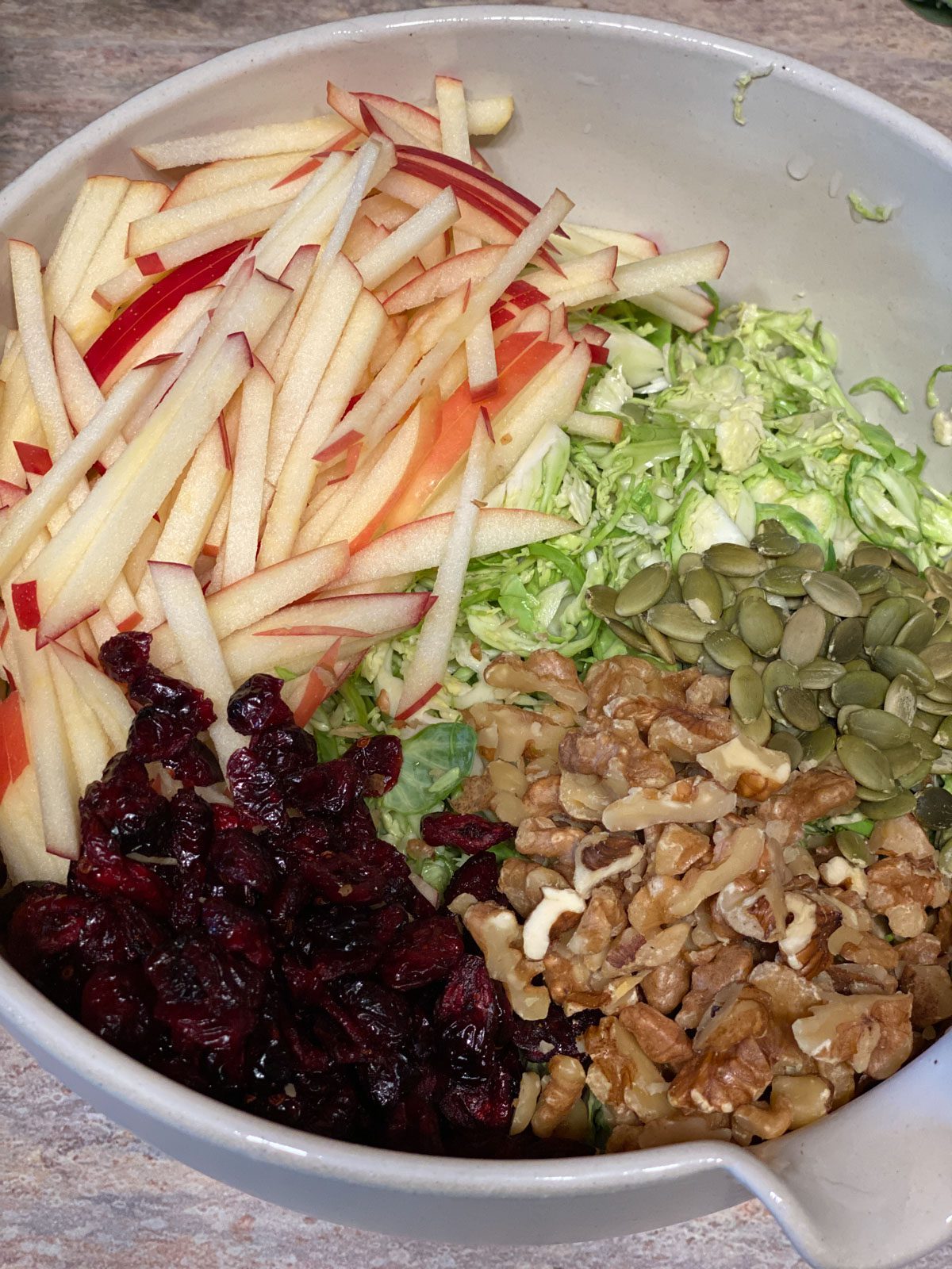 ingredients for Shaved Brussel Sprout Salad sliced in a standard bowl