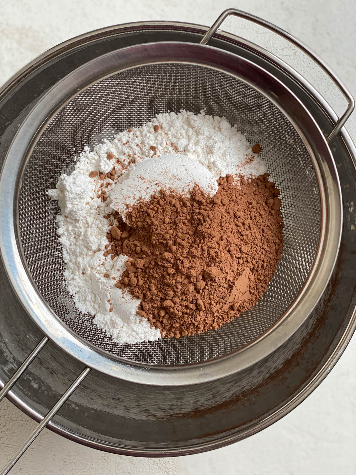 process of ingredients for Vegan Chocolate Frosting in a sifter