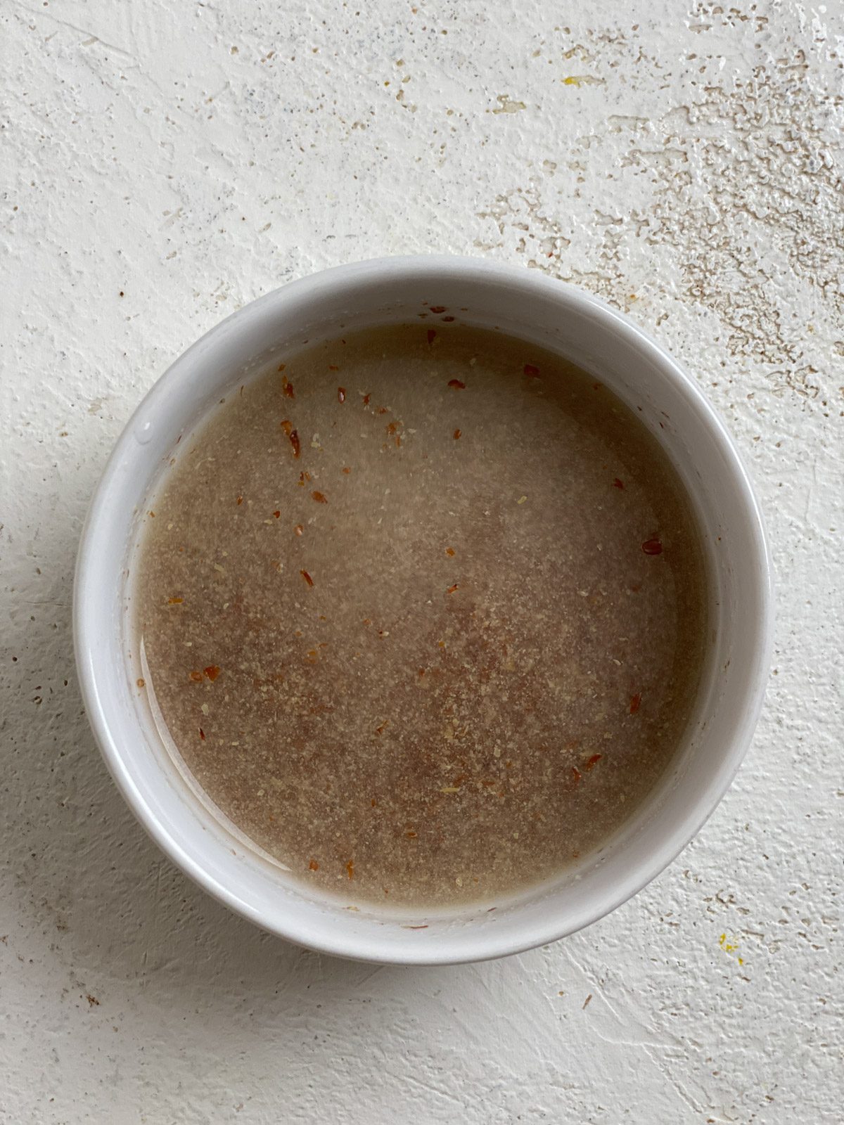 post mixing of water and flaxseed in bowl against white surface