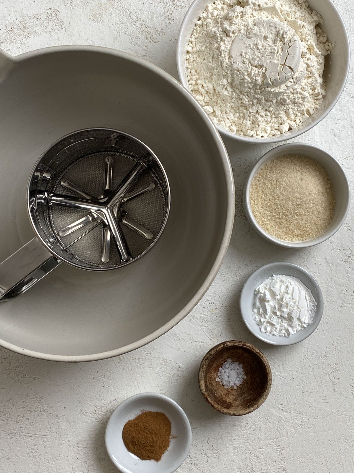 ingredients for Vegan Pumpkin Pancake batter alongside a bowl against a white surface