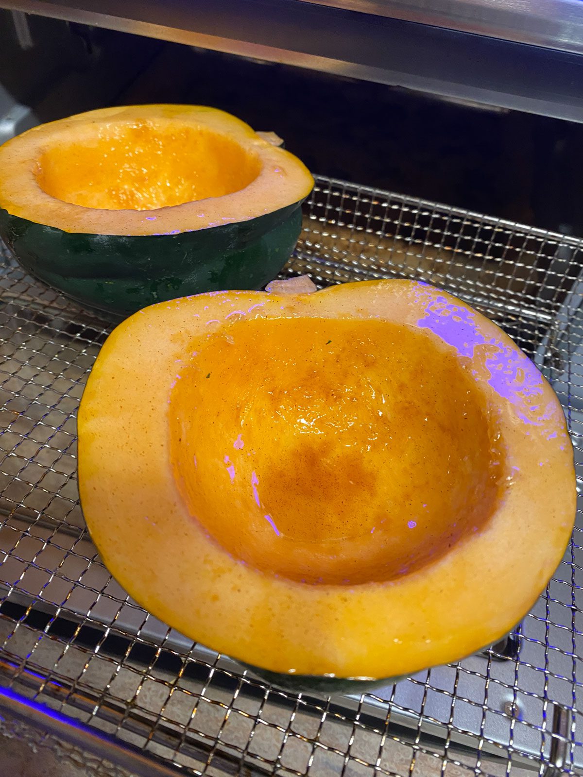 process shot of acorn squash in air fryer prior to being cooked