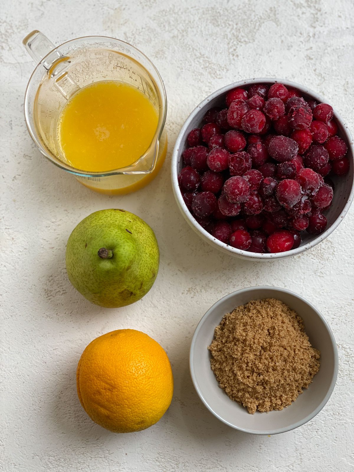 ingredients for Easy Cranberry Pear Sauce measured out against a white surface