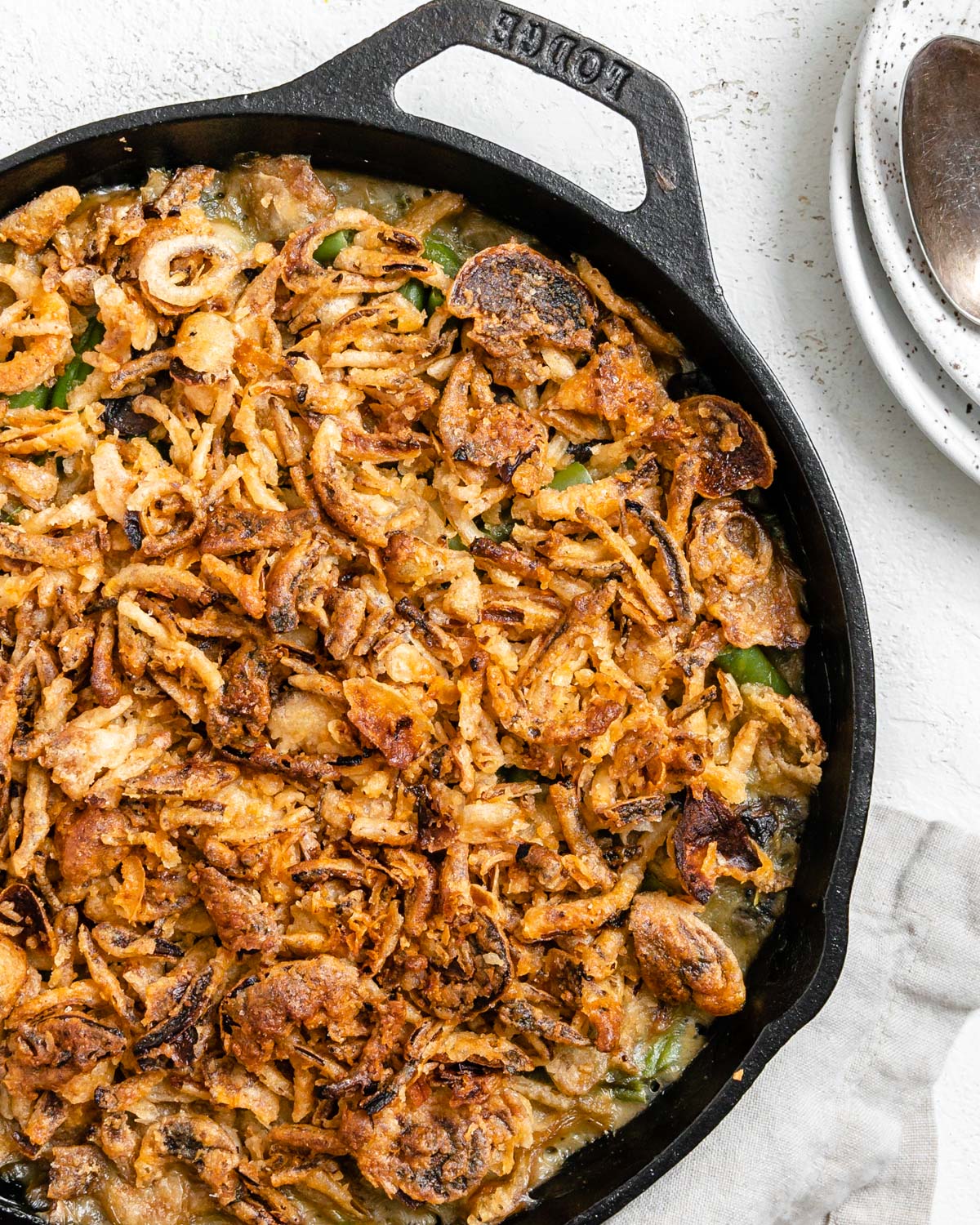 completed Dairy-Free Green Bean Casserole in a skillet against a white background