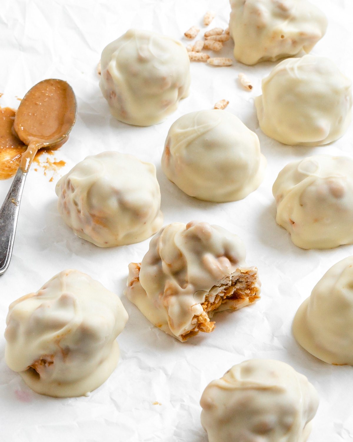 completed Peanut Butter Balls with Rice Krispies scattered on a white surface