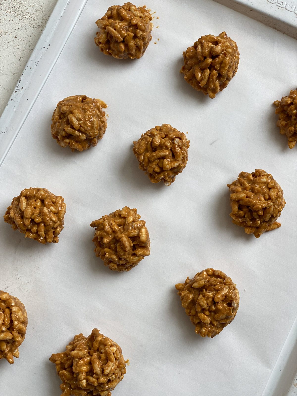 process shot of small cookie balls on a baking sheet prior to being dipped