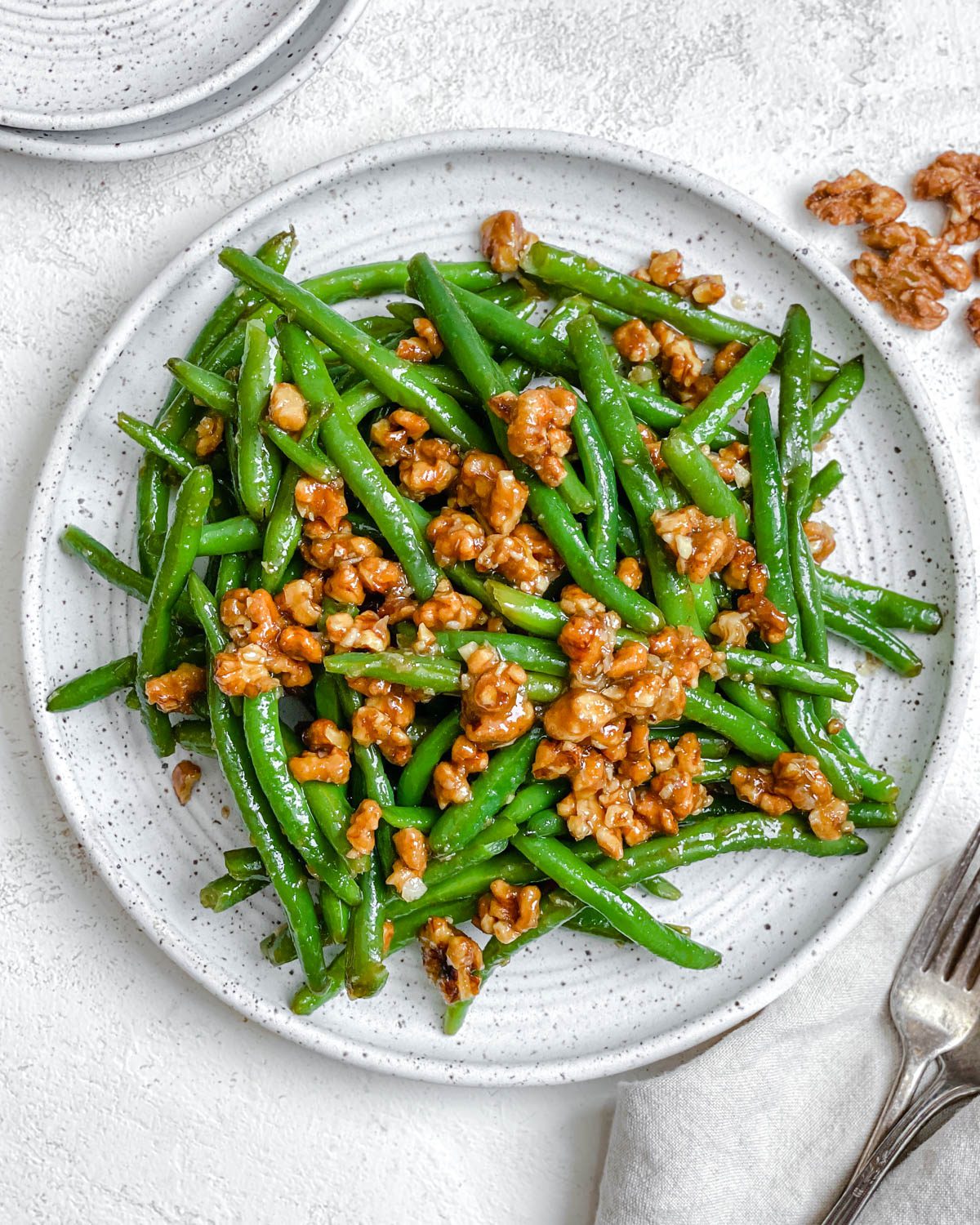 completed Brown Sugar Green Beans [No Bacon] plated on a white plate against a white surface