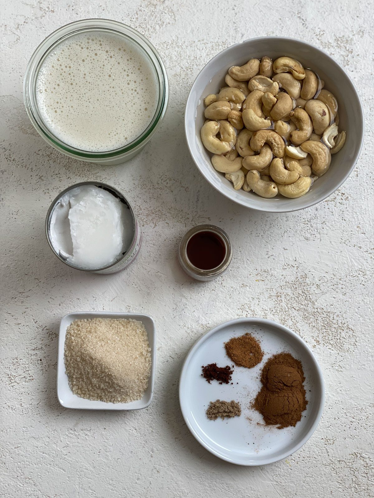 ingredients for Super Creamy Vegan Eggnog measured out against a white surface