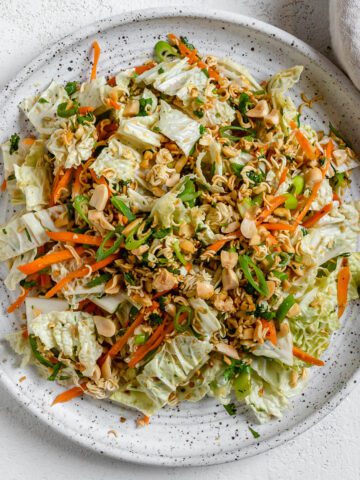 completed Ramen Noodle Cabbage Salad on a white plate against a white background