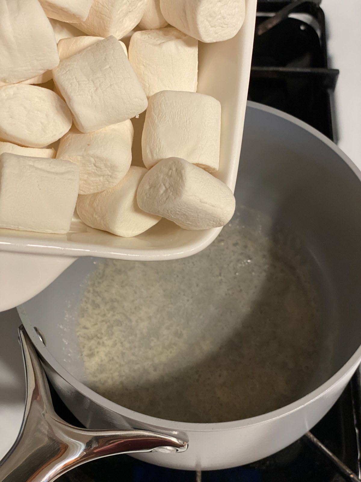 process shot of adding vegan marshmallows to pan