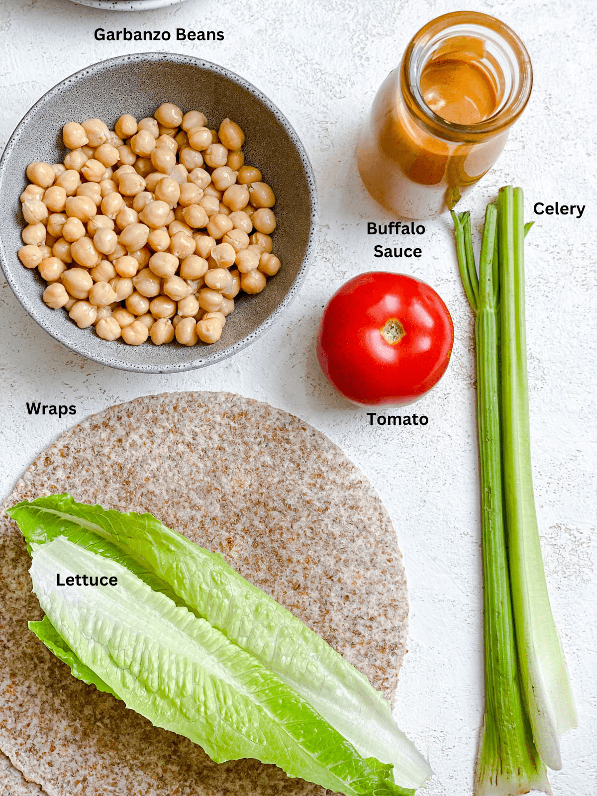 Ingredients for Buffalo Chickpea Wraps measured out on a white surface.