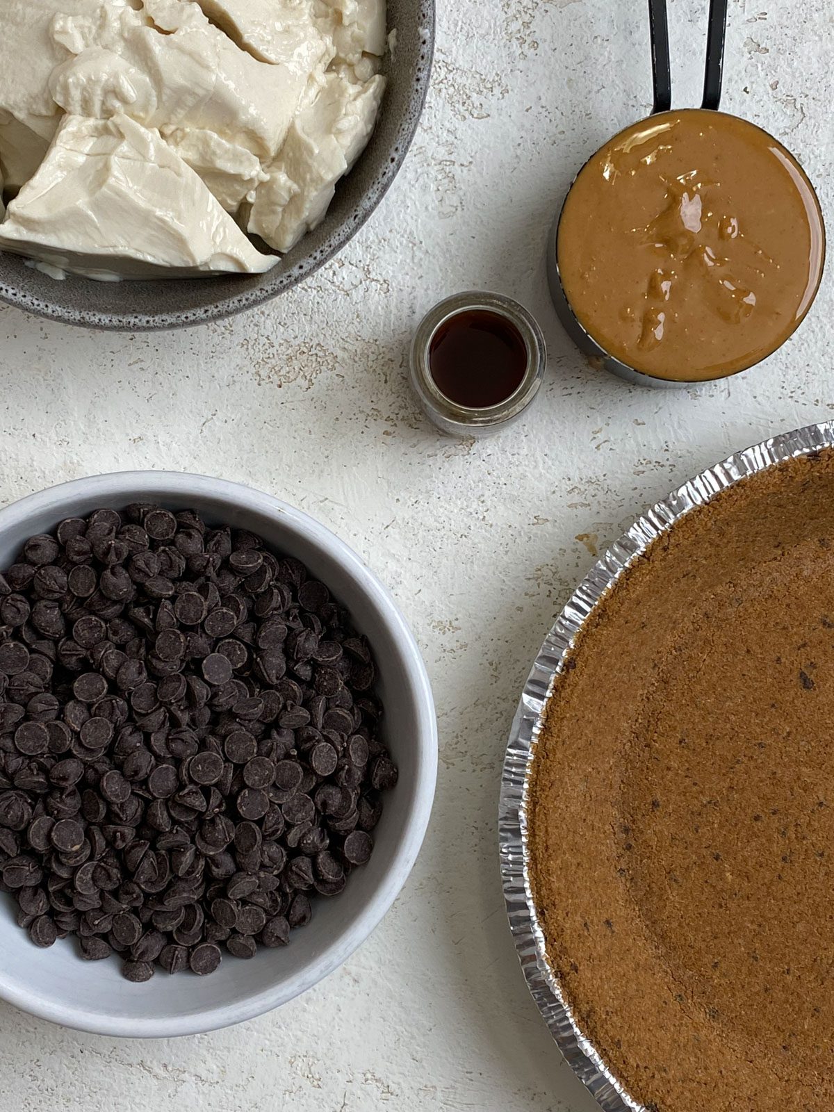 ingredients for Easy Vegan Chocolate Peanut Butter Pie measured out against a white surface