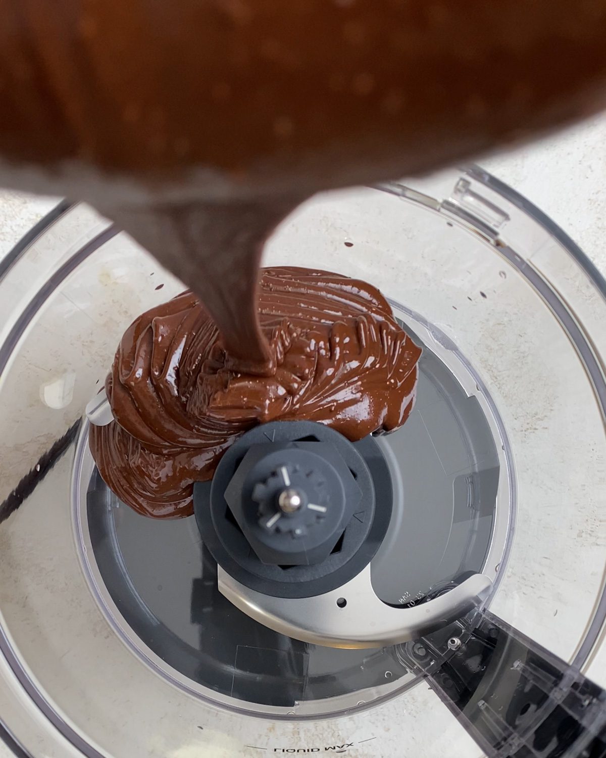 process shot of adding chocolate and peanut butter mixture to food processor