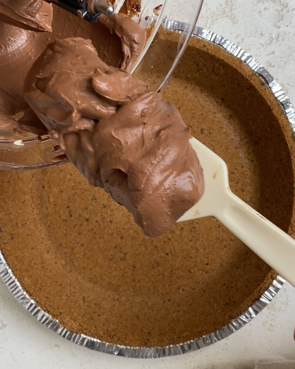 process shot of adding Easy Vegan Chocolate Peanut Butter Pie mixture to pie crust