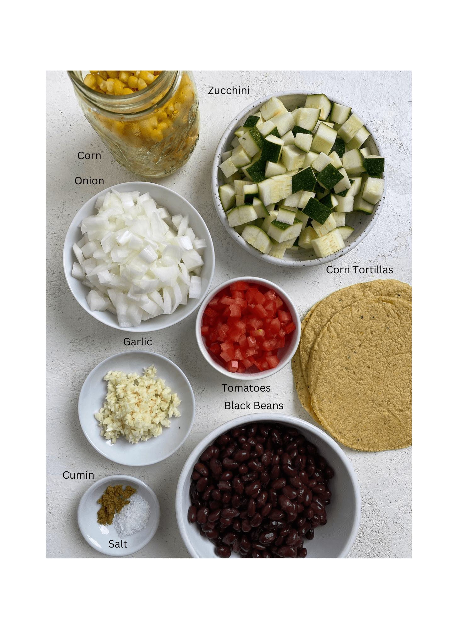 ingredients for Vegan Black Bean Tacos with Veggies measured out against a white surface