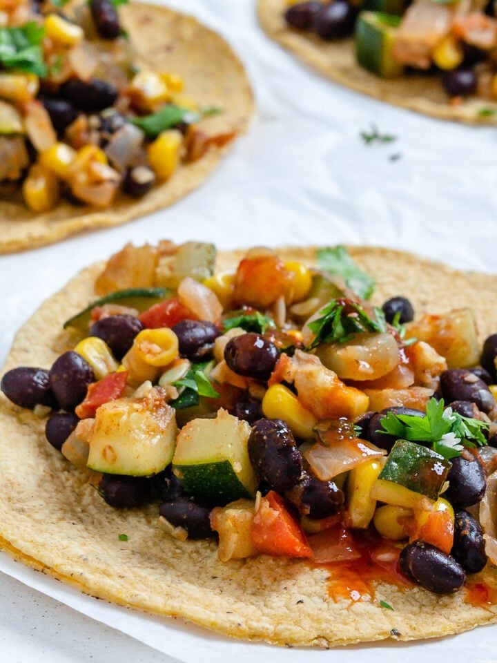 completed Vegan Black Bean Tacos with Veggies against a white surface