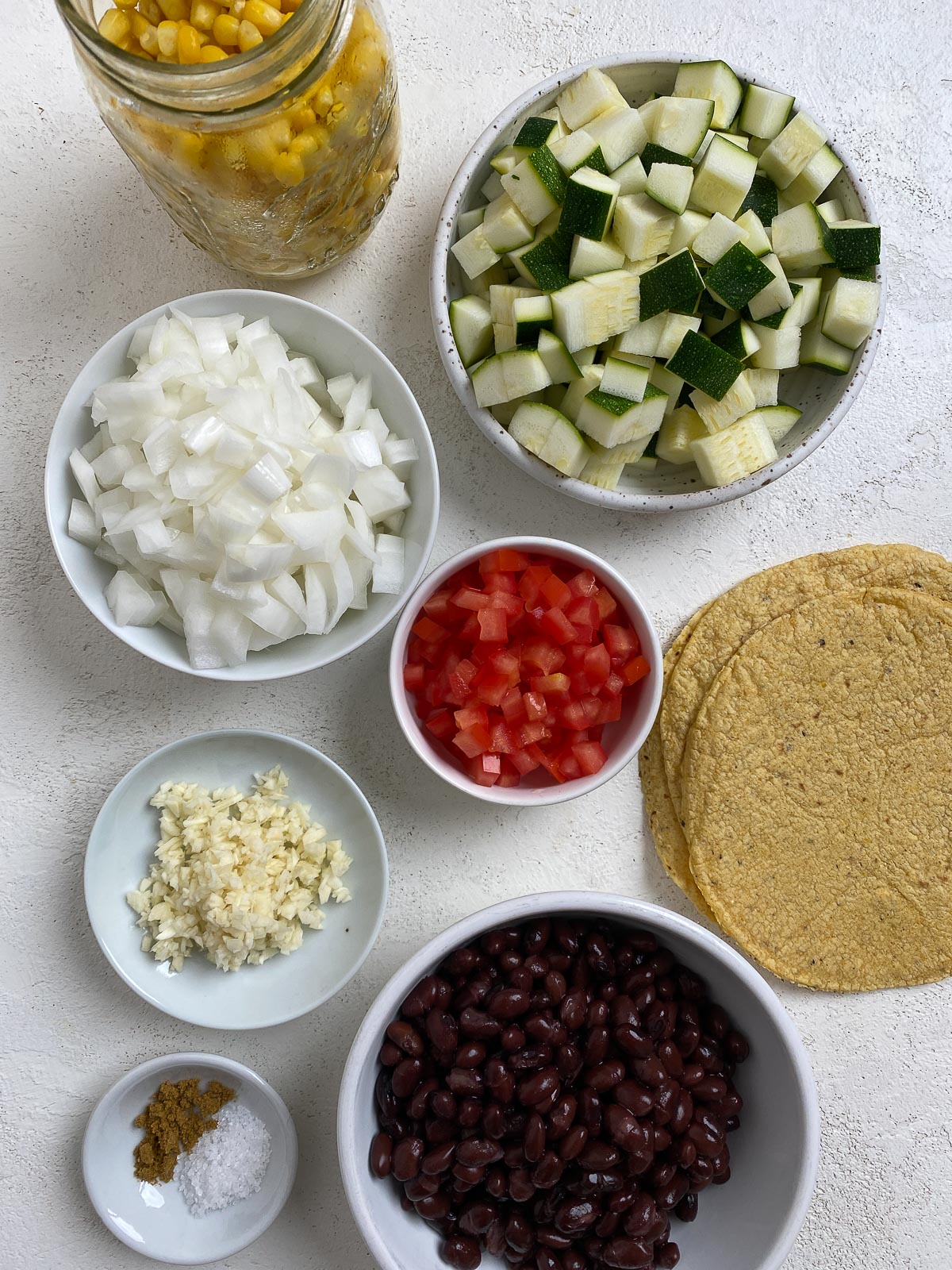 ingredients for Vegan Black Bean Tacos with Veggies measured out against a white surface