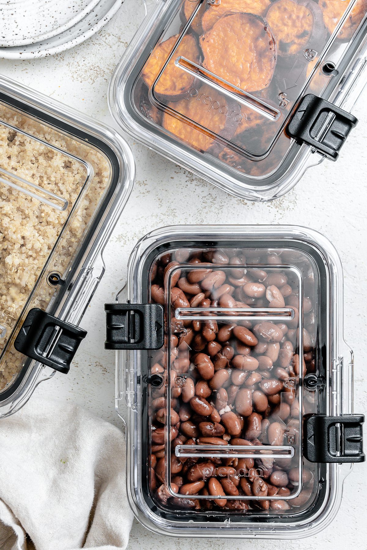 three containers of food against a white surface