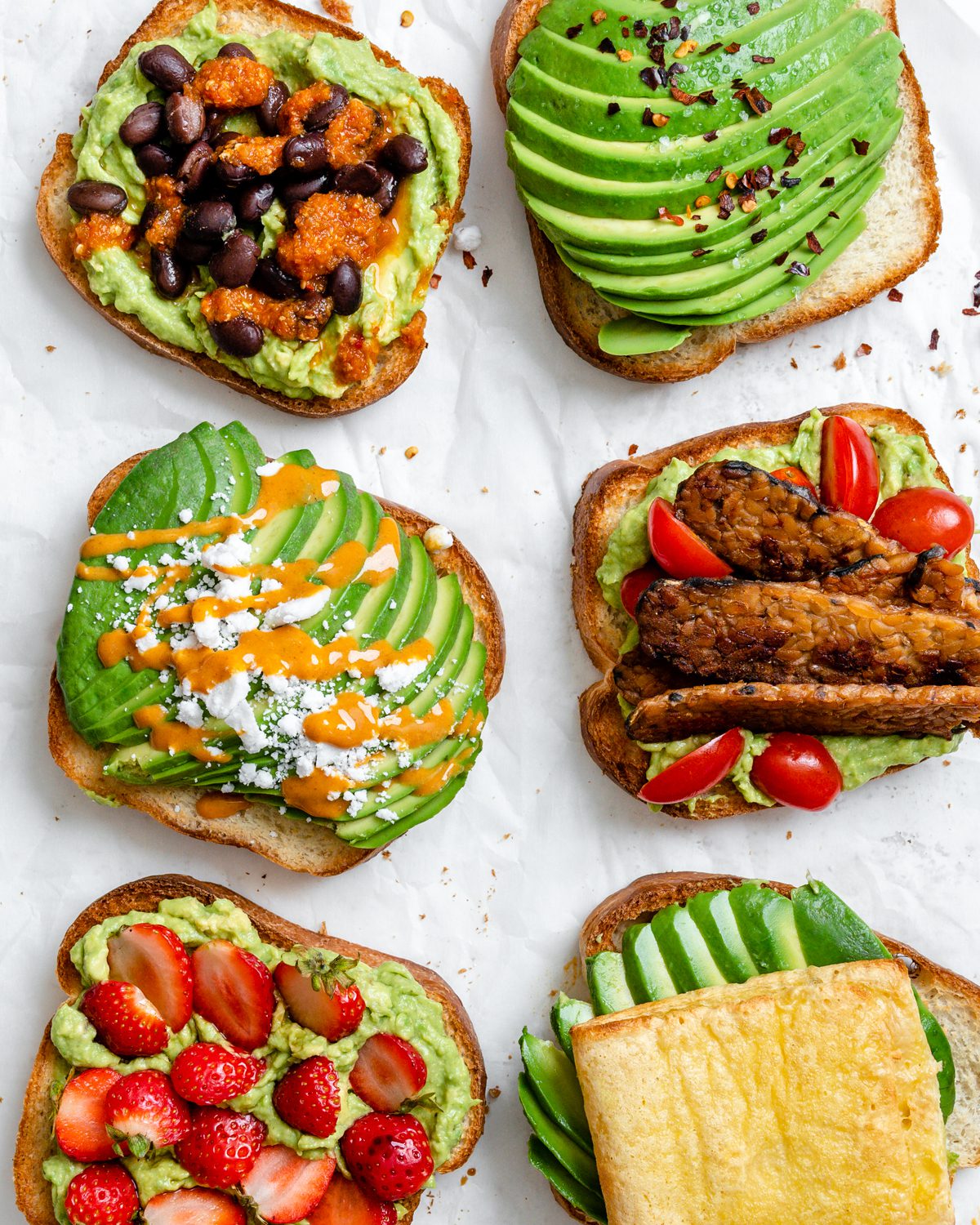 several completed pieces of avocado toast on a white surface