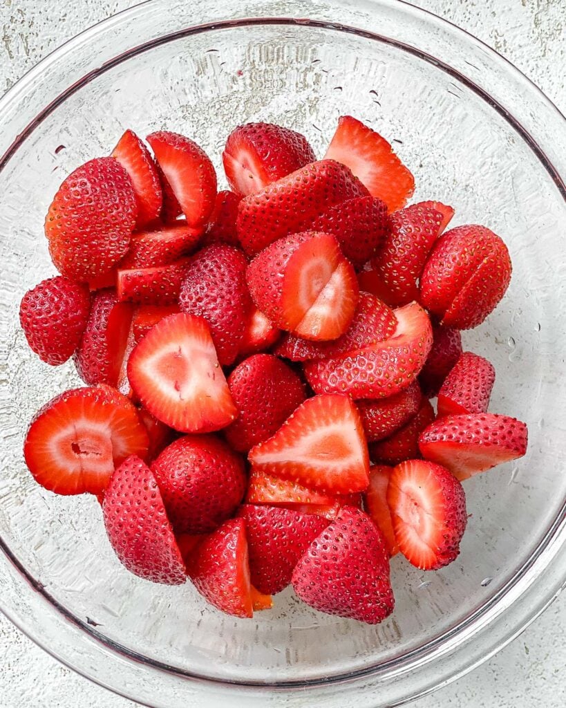 sliced strawberries in a glass bowl