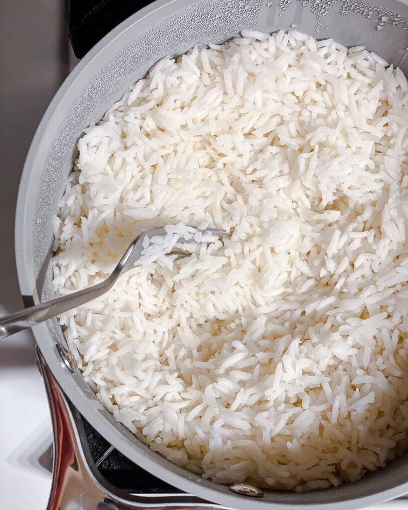 process shot of fluffing up rice with a fork in it's pot