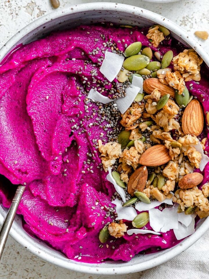 completed Dragon Fruit Smoothie Bowl (Pitaya Bowl) in a bowl against a light surface