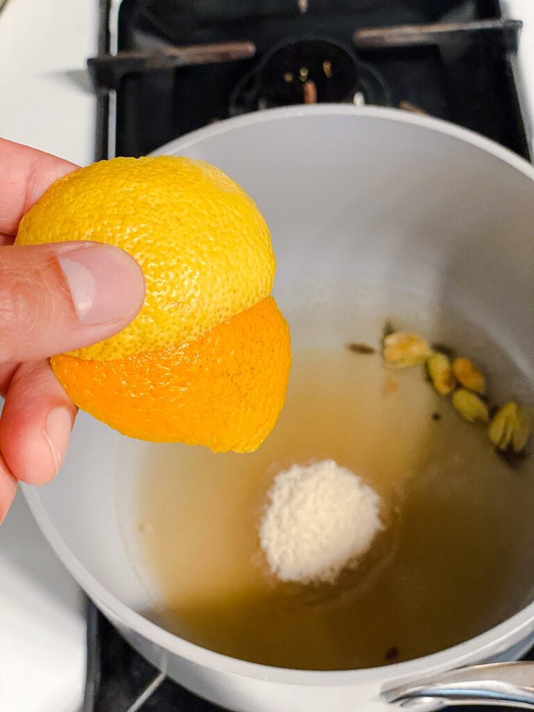 process shot of adding lemon and orange peel to pot