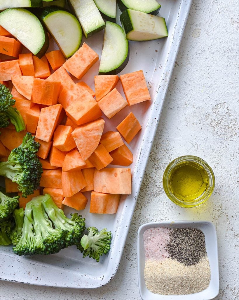 sliced veggies along a cutting board along side spices and oil