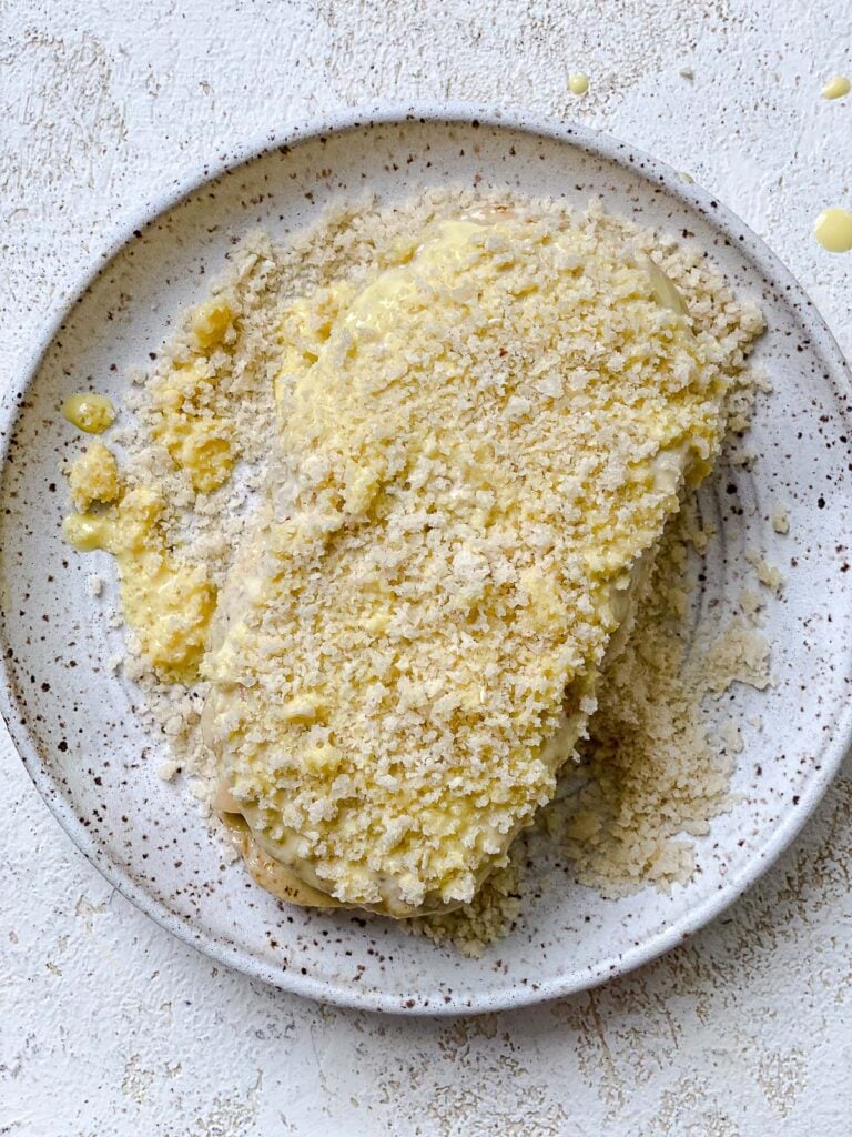 process shot of adding panko bread crumbs to Vegan Cordon Bleu on a plate