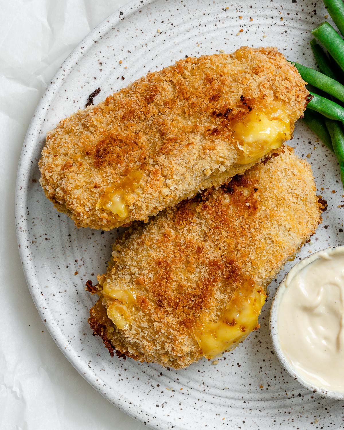 completed Vegan Cordon Bleu plated with green beans and sauce on the side