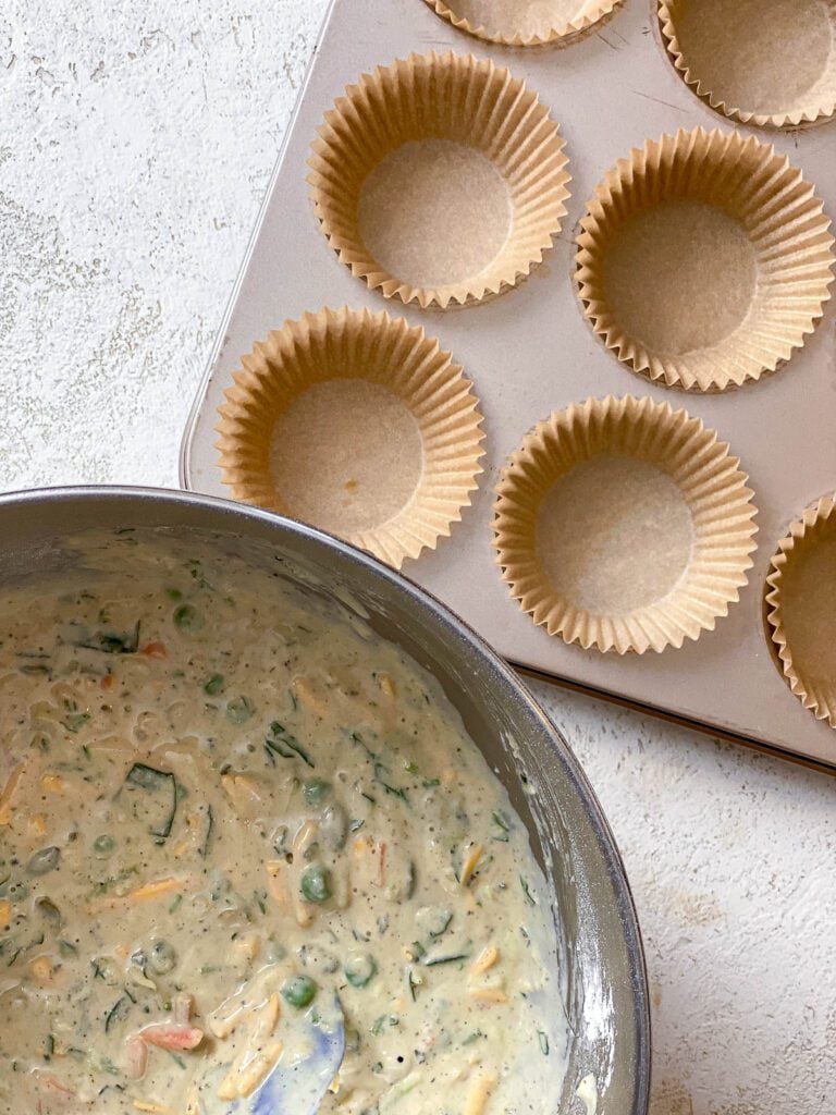 muffin tin alongside bowl of Healthy Veggie Muffins batter