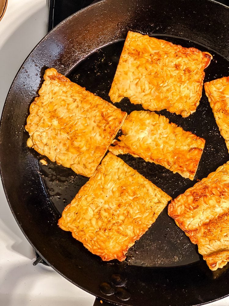 process shot of tempeh cooking on skillet
