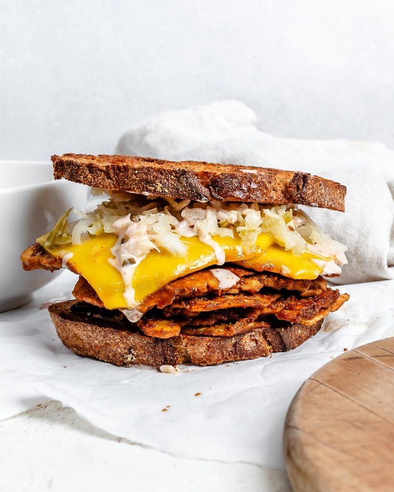 completed Vegan Reuben Sandwich against white surface