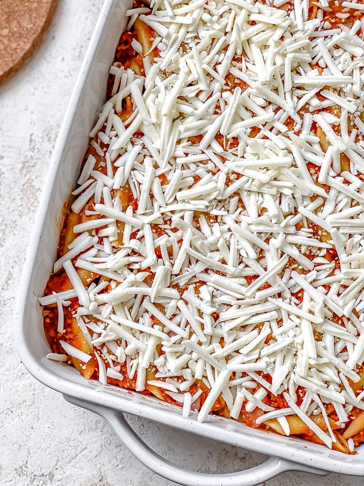 process shot showing vegan cheese added to baking dish